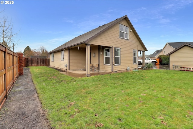 rear view of house featuring a lawn and a patio