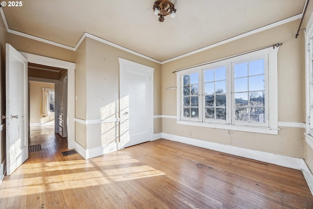 empty room featuring hardwood / wood-style floors and ornamental molding