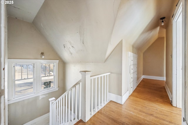 hallway featuring vaulted ceiling and light wood-type flooring