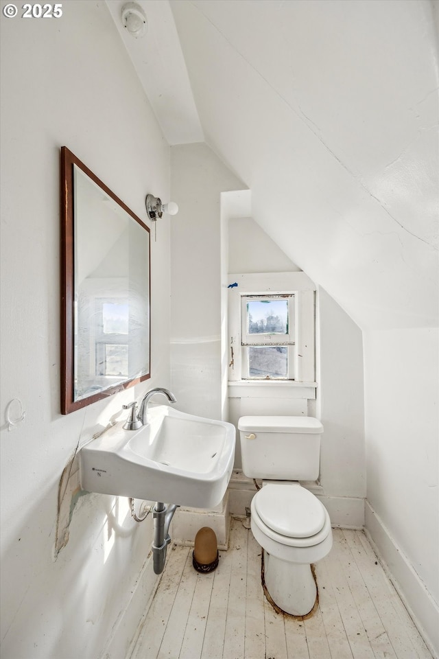 bathroom with sink, hardwood / wood-style flooring, vaulted ceiling, and toilet