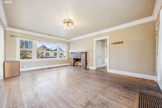 unfurnished living room featuring a tiled fireplace, hardwood / wood-style floors, and ornamental molding