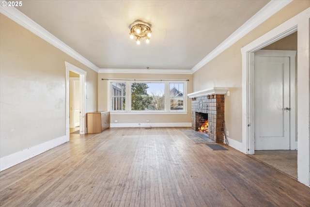 unfurnished living room with crown molding, a tiled fireplace, and hardwood / wood-style flooring