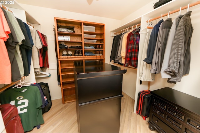 walk in closet with light hardwood / wood-style floors