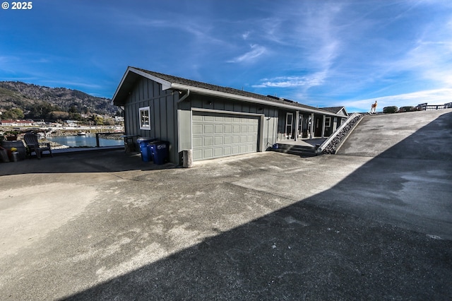 view of property exterior with a garage and a water and mountain view