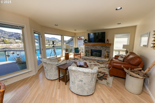 living room featuring a fireplace, a mountain view, and light hardwood / wood-style flooring