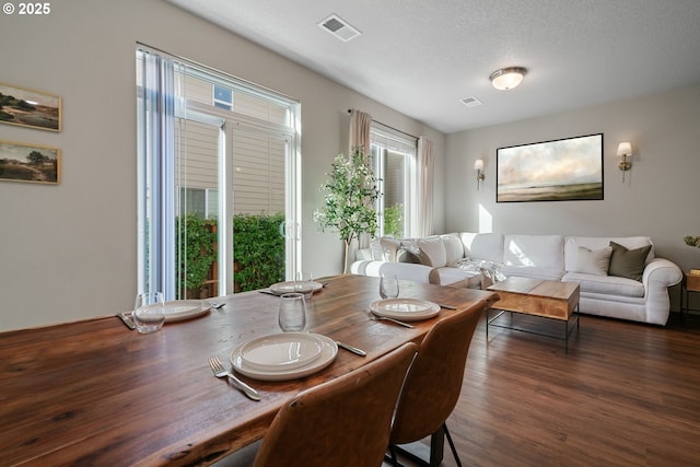 dining area featuring a textured ceiling and dark hardwood / wood-style flooring