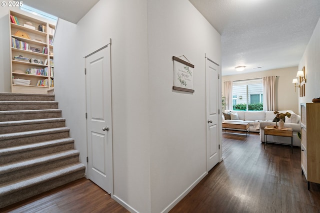 hall featuring dark hardwood / wood-style flooring and a textured ceiling