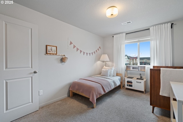 bedroom featuring carpet flooring and a textured ceiling