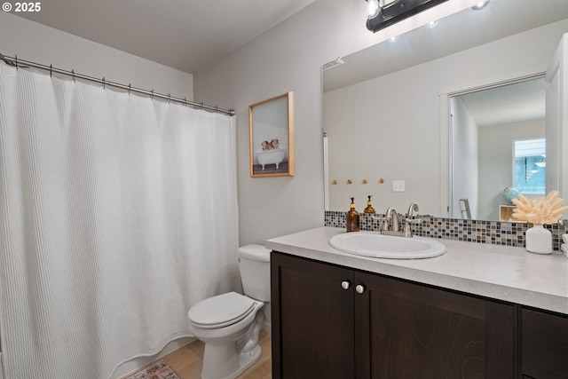 bathroom featuring toilet, vanity, tasteful backsplash, and tile patterned floors