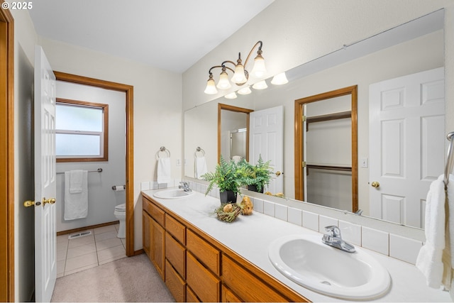 bathroom with tile patterned flooring, vanity, and toilet