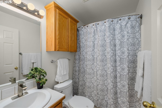 bathroom with vanity, curtained shower, and toilet