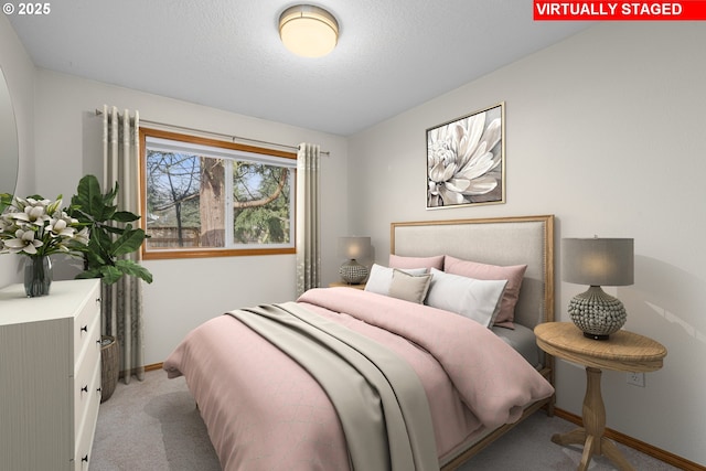 bedroom with light carpet and a textured ceiling