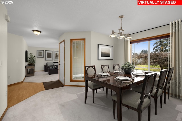 carpeted dining area featuring a textured ceiling and a notable chandelier