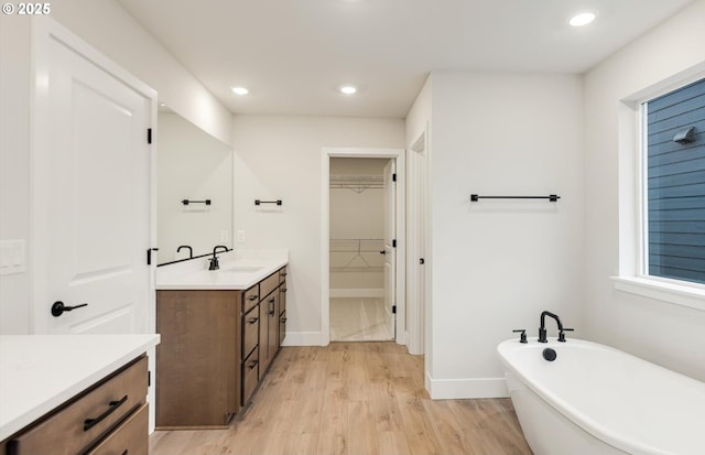 366 S 87th Ave, Ridgefield, WA 98642 - bathroom with vanity, a freestanding tub, recessed lighting, wood finished floors, and a spacious closet