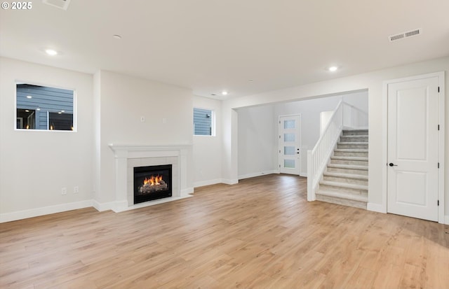 366 S 87th Ave, Ridgefield, WA 98642 - unfurnished living room with light wood-type flooring, stairway, a tile fireplace, recessed lighting, and baseboards
