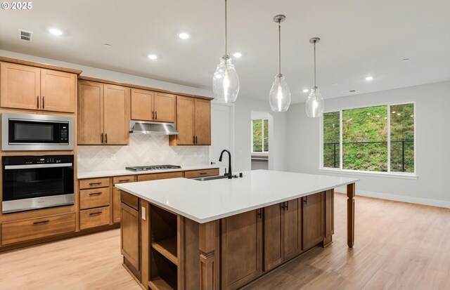 366 S 87th Ave, Ridgefield, WA 98642 - kitchen with oven, a sink, built in microwave, decorative backsplash, and an island with sink