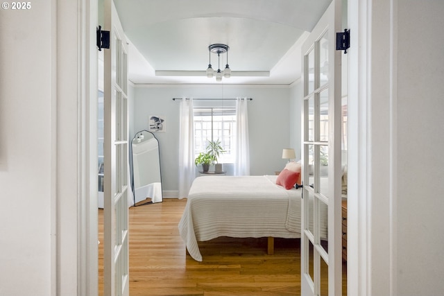 2829 SE Belmont St Unit 205, Portland, OR 97214 - bedroom featuring a raised ceiling, light wood-type flooring, french doors, and a ceiling fan