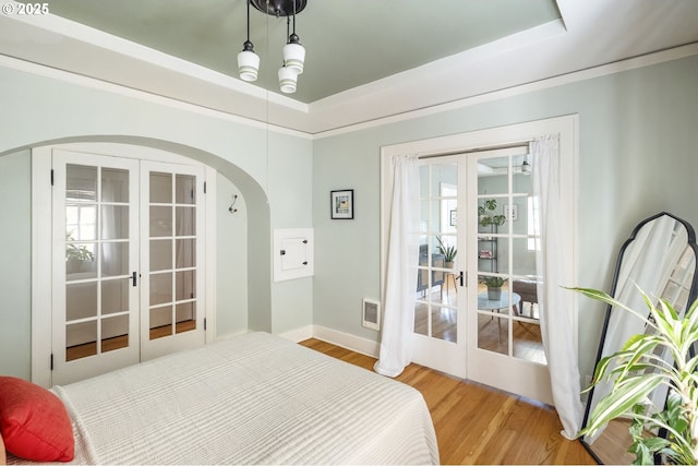 2829 SE Belmont St Unit 205, Portland, OR 97214 - bedroom with french doors, arched walkways, wood finished floors, and a tray ceiling