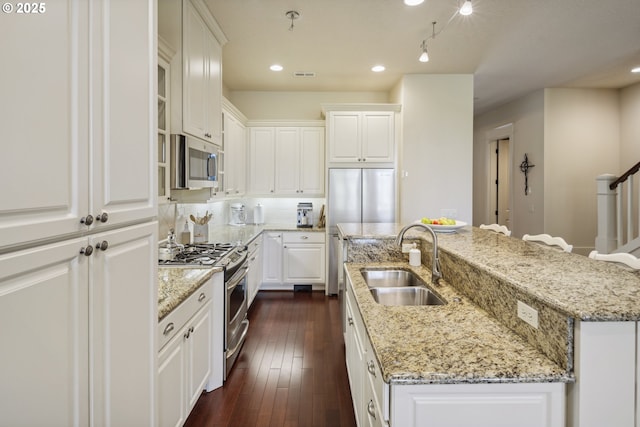 10135 SW Morrison St, Portland, OR 97225 - kitchen with stainless steel appliances, a center island with sink, a sink, white cabinetry, and recessed lighting