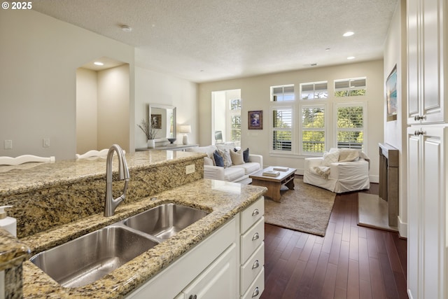 10135 SW Morrison St, Portland, OR 97225 - kitchen featuring a sink, open floor plan, a textured ceiling, light stone countertops, and white cabinets