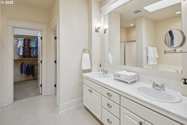10135 SW Morrison St, Portland, OR 97225 - full bathroom featuring double vanity, a skylight, baseboards, a spacious closet, and a shower stall