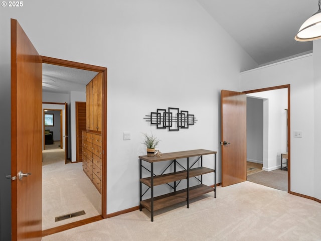 hallway featuring light carpet and lofted ceiling