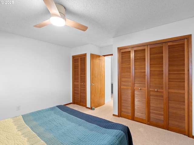 bedroom featuring a textured ceiling, ceiling fan, and light carpet