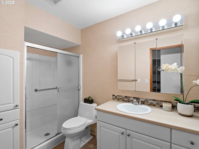 bathroom featuring toilet, an enclosed shower, vanity, and decorative backsplash