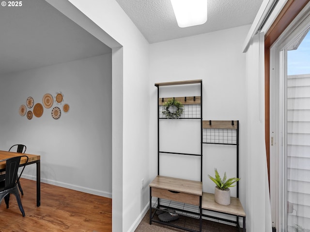 hallway featuring a textured ceiling and hardwood / wood-style floors