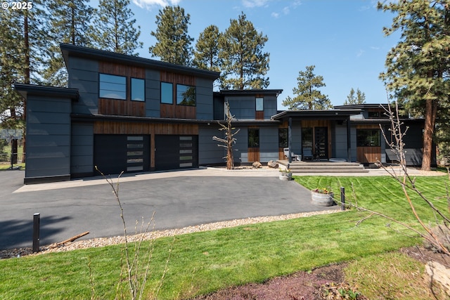 contemporary home with an attached garage, driveway, and a front yard