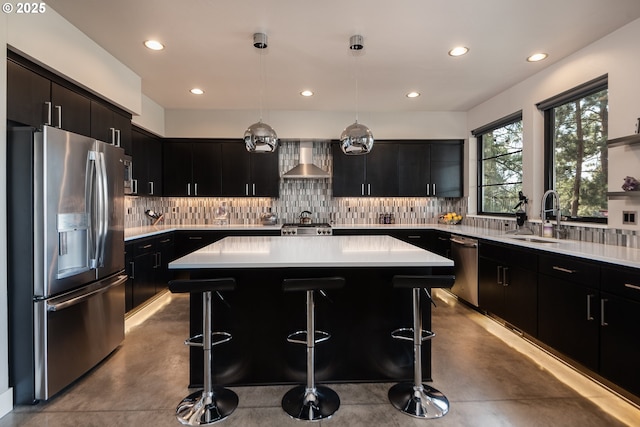 kitchen with appliances with stainless steel finishes, concrete flooring, wall chimney range hood, dark cabinets, and recessed lighting