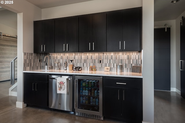 indoor wet bar featuring a barn door, wine cooler, concrete floors, and backsplash