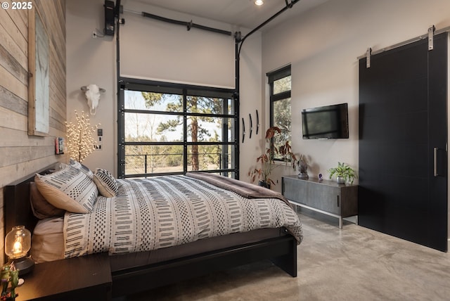 bedroom with finished concrete floors and a towering ceiling