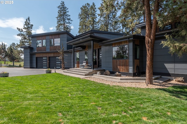 modern home with asphalt driveway, a garage, and a front lawn
