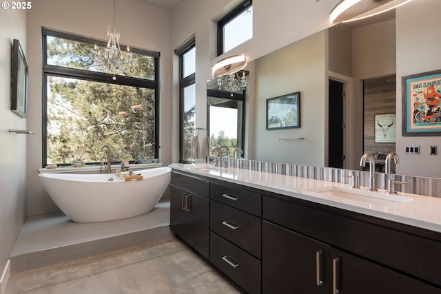 full bath with healthy amount of natural light, a freestanding tub, and double vanity