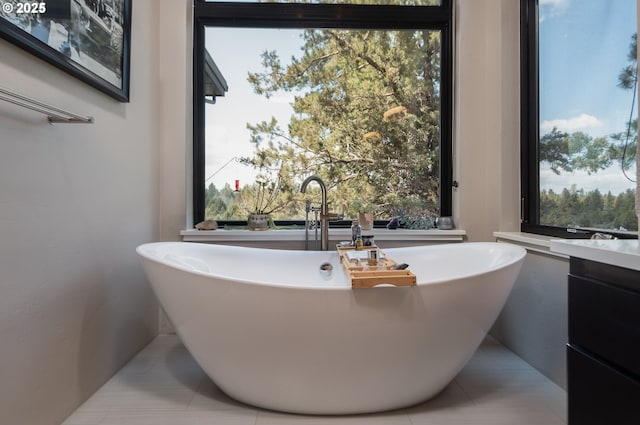 bathroom featuring a freestanding tub, tile patterned floors, and healthy amount of natural light