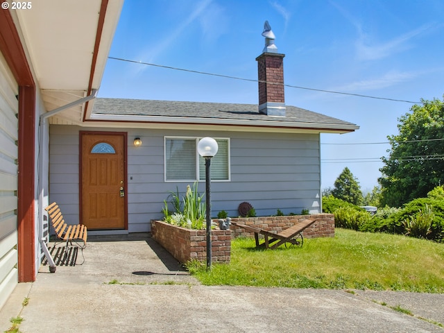 450 Pleasant Ave, Astoria, OR 97103 - view of exterior entry featuring roof with shingles and a chimney