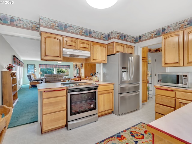 450 Pleasant Ave, Astoria, OR 97103 - kitchen with appliances with stainless steel finishes, light flooring, light countertops, under cabinet range hood, and a peninsula