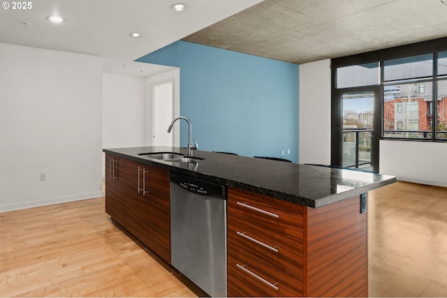 kitchen featuring a sink, dishwasher, light wood finished floors, an island with sink, and modern cabinets