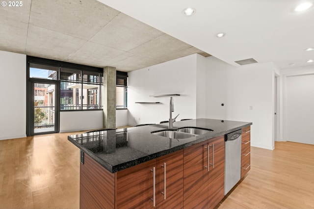 kitchen with a sink, modern cabinets, light wood-type flooring, a large island with sink, and dishwasher