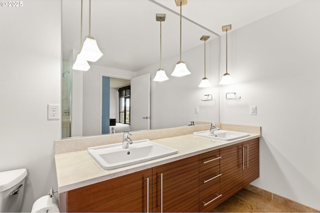 full bathroom with double vanity, toilet, and a sink