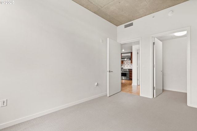 unfurnished bedroom with carpet, visible vents, and baseboards