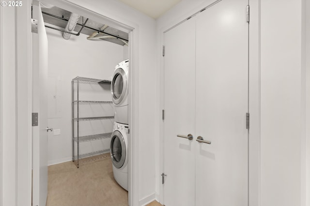 clothes washing area featuring laundry area and stacked washing maching and dryer