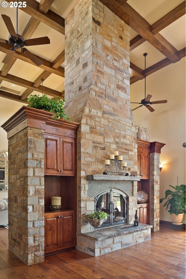 16465 Suntree Ln, Sisters, OR 97759 - living area featuring a stone fireplace, coffered ceiling, ceiling fan, beam ceiling, and hardwood / wood-style floors