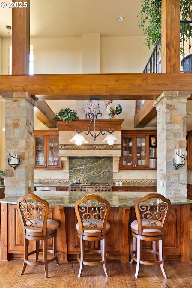 16465 Suntree Ln, Sisters, OR 97759 - bar area with tasteful backsplash, decorative columns, and light wood-type flooring