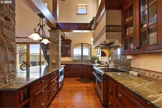 16465 Suntree Ln, Sisters, OR 97759 - kitchen with appliances with stainless steel finishes, decorative backsplash, pendant lighting, dark wood finished floors, and a towering ceiling