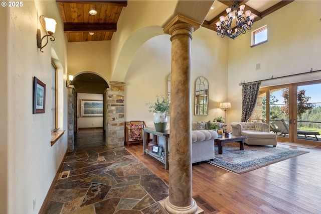 16465 Suntree Ln, Sisters, OR 97759 - living area featuring ornate columns, a towering ceiling, arched walkways, wooden ceiling with exposed beams, and hardwood / wood-style flooring