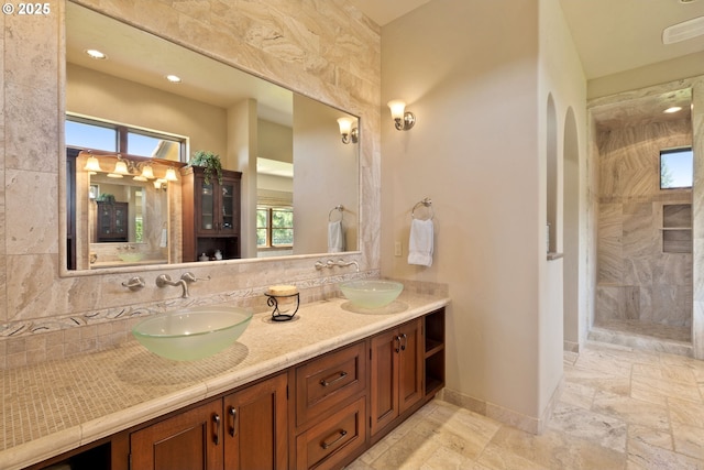 16465 Suntree Ln, Sisters, OR 97759 - full bathroom featuring double vanity, a tile shower, decorative backsplash, baseboards, and recessed lighting