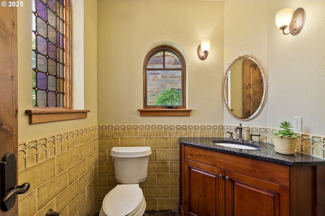 16465 Suntree Ln, Sisters, OR 97759 - bathroom featuring tile walls, a wainscoted wall, toilet, and vanity