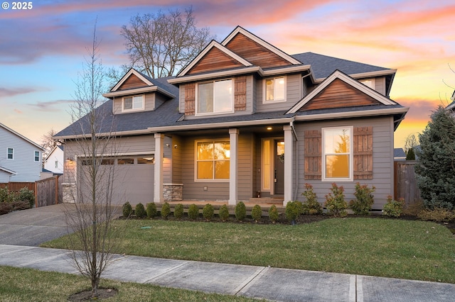 craftsman-style home with a garage, a lawn, and covered porch